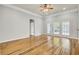 Bright living room with hardwood floors, three windows, and an open doorway at 8001 Hydrangea Ln, Hanahan, SC 29410