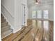 Open-concept living space with hardwood floors, base molding, and large windows at 8001 Hydrangea Ln, Hanahan, SC 29410