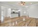 Open-concept living room showcasing hardwood floors and a kitchen with stainless steel appliances at 8001 Hydrangea Ln, Hanahan, SC 29410