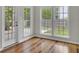 Sunroom with hardwood floors and multiple windows offering views of the backyard at 8001 Hydrangea Ln, Hanahan, SC 29410