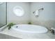 Modern bathroom with a tub, stylish tile, and a circular window at 1011 Lighterman Way, Charleston, SC 29412