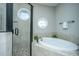 Contemporary bathroom features a glass shower, tub, and stylish circular windows at 1011 Lighterman Way, Charleston, SC 29412
