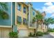 Colorful townhome exterior showing private garages, palm trees, and well-maintained landscaping at 1011 Lighterman Way, Charleston, SC 29412