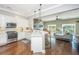 Open concept kitchen featuring stainless steel appliances, granite countertops, and a view of the living area with hardwood floors at 1011 Lighterman Way, Charleston, SC 29412