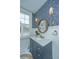 Stylish bathroom features blue wallpaper, round mirror and vanity sink at 1075 Avenue Of Oaks, Charleston, SC 29407