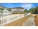 Two-story home with white picket fence, detached garage, professional landscaping, and ample curb appeal at 1075 Avenue Of Oaks, Charleston, SC 29407