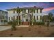Charming two-story home featuring a symmetrical design, palm trees, and brick steps at 1075 Avenue Of Oaks, Charleston, SC 29407