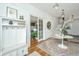 Bright foyer featuring hardwood floors, elegant lighting, coat rack, and seamless transition to adjacent living spaces at 1075 Avenue Of Oaks, Charleston, SC 29407