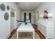 Well-lit hallway with a white writing desk, wood floors, and art at 1075 Avenue Of Oaks, Charleston, SC 29407