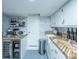 Well stocked bar area featuring a wine refrigerator, sink with wooden countertop, and custom wallpaper at 1075 Avenue Of Oaks, Charleston, SC 29407