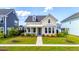 Charming two-story home with a inviting front porch, colorful landscaping, and well maintained lawn at 113 Grimball St, Summerville, SC 29486