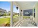 Charming front porch with rocking chairs and colorful hanging plants, surrounded by well-manicured landscaping at 113 Grimball St, Summerville, SC 29486