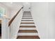 Well-lit staircase with hardwood steps, white risers, and a dark wood handrail at 113 Grimball St, Summerville, SC 29486