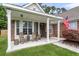 Inviting front porch with rocking chairs, brick columns, and a well-kept lawn and garden at 117 Back Tee Cir, Summerville, SC 29485