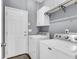 Functional laundry room with modern washer and dryer, white cabinets, and convenient shelving at 117 Back Tee Cir, Summerville, SC 29485