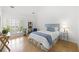 Serene bedroom featuring a vaulted ceiling, hardwood floors, and a comfortable bed with stylish blue accents and bright natural light at 1177 Old Ivy Way, Mount Pleasant, SC 29466