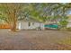 View of the home's rear exterior, showcasing the brick facade, back door, and spacious yard with mature trees at 1188 Camden St, North Charleston, SC 29405