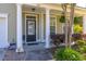 Charming front porch with black front door and white columns surrounded by lush landscaping at 120 Fresh Meadow Ln, Mount Pleasant, SC 29466