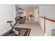 Upstairs landing area with exercise bike and a cozy sitting area with chair and accent lamps at 120 Fresh Meadow Ln, Mount Pleasant, SC 29466