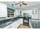 Bright kitchen featuring white cabinets, black countertops and stainless steel appliances at 123 Tiffany Ln, Summerville, SC 29485