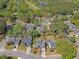 Aerial view of a residential area with tree-lined streets, manicured lawns, and a golf course in the distance at 1310 Belhaven Dr, Mount Pleasant, SC 29466