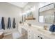 Bright primary bathroom with a double vanity, mirrors, and blue towels at 1310 Belhaven Dr, Mount Pleasant, SC 29466