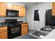 Modern kitchen showcasing a black microwave and oven, paired with wood cabinets for a sleek look at 1314 Garland St, North Charleston, SC 29420