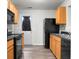 Functional kitchen featuring black appliances, wood cabinets, and a sink for efficient meal preparation at 1314 Garland St, North Charleston, SC 29420