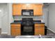 The kitchen features wooden cabinetry, black countertops and black appliances at 1314 Garland St, North Charleston, SC 29420