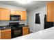 Well-equipped kitchen with modern black appliances and wood cabinets for a sleek and functional cooking experience at 1314 Garland St, North Charleston, SC 29420