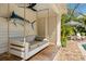Outdoor cabana with bench swing, marlin decor and seating with a striped umbrella at 1316 Thompson, Sullivans Island, SC 29482