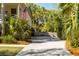 Long driveway leads to a charming home, enhanced by lush, mature landscaping and a welcoming American flag at 1316 Thompson, Sullivans Island, SC 29482