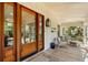 Inviting front porch with seating, wooden floors, and a beautifully crafted wooden front door at 1316 Thompson, Sullivans Island, SC 29482