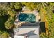 Aerial view of a private pool surrounded by lush greenery, umbrellas, and a sunbathing area at 1316 Thompson, Sullivans Island, SC 29482