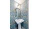 Charming powder room with beautiful floral wallpaper and classic pedestal sink at 1316 Thompson, Sullivans Island, SC 29482