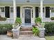 Charming home entrance with black door, decorative sidelights, brick steps, and lush potted plants at 141 Beaufain St, Charleston, SC 29401