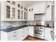 Stylish kitchen with white cabinets, marble backsplash, stainless steel appliances, and dark countertops at 141 Beaufain St, Charleston, SC 29401