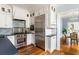 Bright kitchen with stainless steel appliances, custom white cabinetry, and hardwood floors at 141 Beaufain St, Charleston, SC 29401