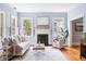 Bright living room with hardwood floors, fireplace, large windows, and elegant white furniture at 141 Beaufain St, Charleston, SC 29401