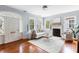 Bright living room with hardwood floors, fireplace, large windows, and elegant white furniture at 141 Beaufain St, Charleston, SC 29401