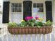 Close-up of a charming window box bursting with colorful pink, yellow, and white flowers at 141 Beaufain St, Charleston, SC 29401
