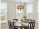 Sunlit dining room with large windows, stylish chandelier, and elegant table setting for entertaining at 144 Sandy Bend Ln, Summerville, SC 29486