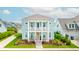 Charming two-story home with a welcoming double porch, adorned with chairs and a peach-colored front door at 144 Sandy Bend Ln, Summerville, SC 29486