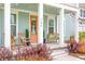 Inviting front porch with rocking chairs, a cozy bench, and a decorative wreath on the peach colored door at 144 Sandy Bend Ln, Summerville, SC 29486