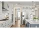 Modern kitchen boasts white cabinetry, stainless steel appliances, and a spacious center island with pendant lighting at 144 Sandy Bend Ln, Summerville, SC 29486