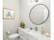 Stylish powder room featuring a marble countertop, round mirror, and elegant fixtures at 144 Sandy Bend Ln, Summerville, SC 29486