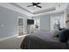 This main bedroom features a tray ceiling, a ceiling fan, and two windows for natural light at 147 Musket Loop, Summerville, SC 29483