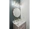 This powder room includes unique mirror, gold lighting fixtures, and a gray vanity at 1504 Galloway Ln, Charleston, SC 29412