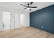 Stylish bedroom with wood-look floors, blue accent wall and ensuite bathroom at 1504 Galloway Ln, Charleston, SC 29412