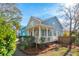 Charming blue home featuring a front porch, landscaped yard and mature trees at 1504 Galloway Ln, Charleston, SC 29412